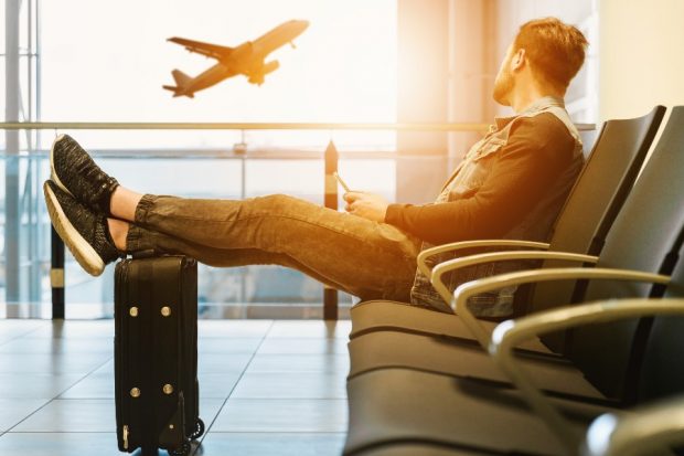 Wachtende passagier kijkt naar opstijgend vliegtuig